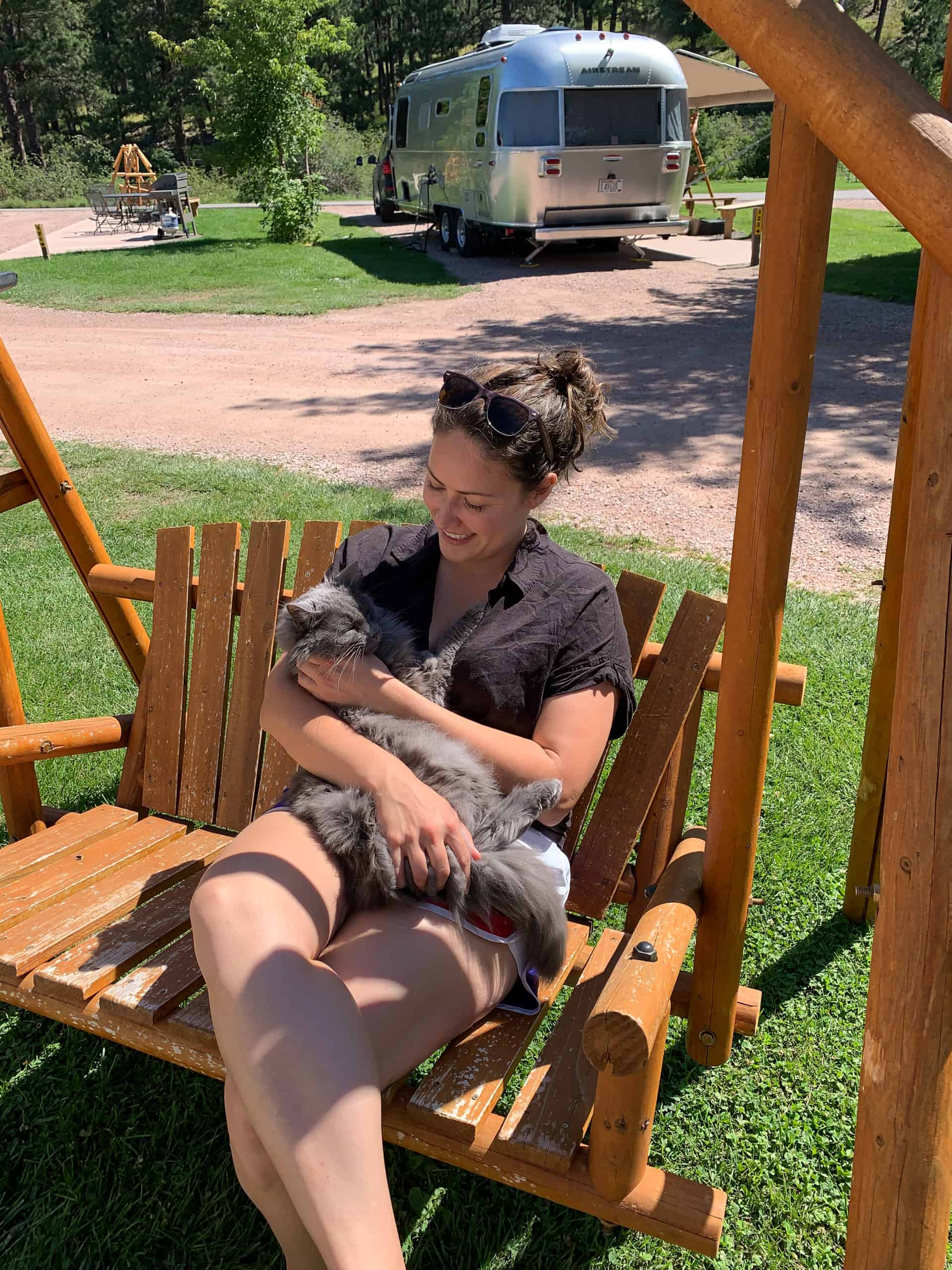 Cindy on swinging bench with cat at the Mount Rushmore KOA at Palmer Gulch Resort