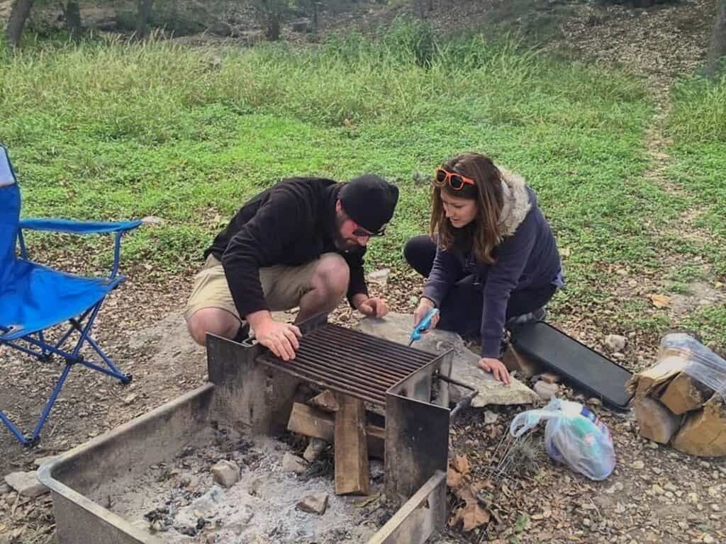 Cindy and Barrett starting a fire with long handled lighter