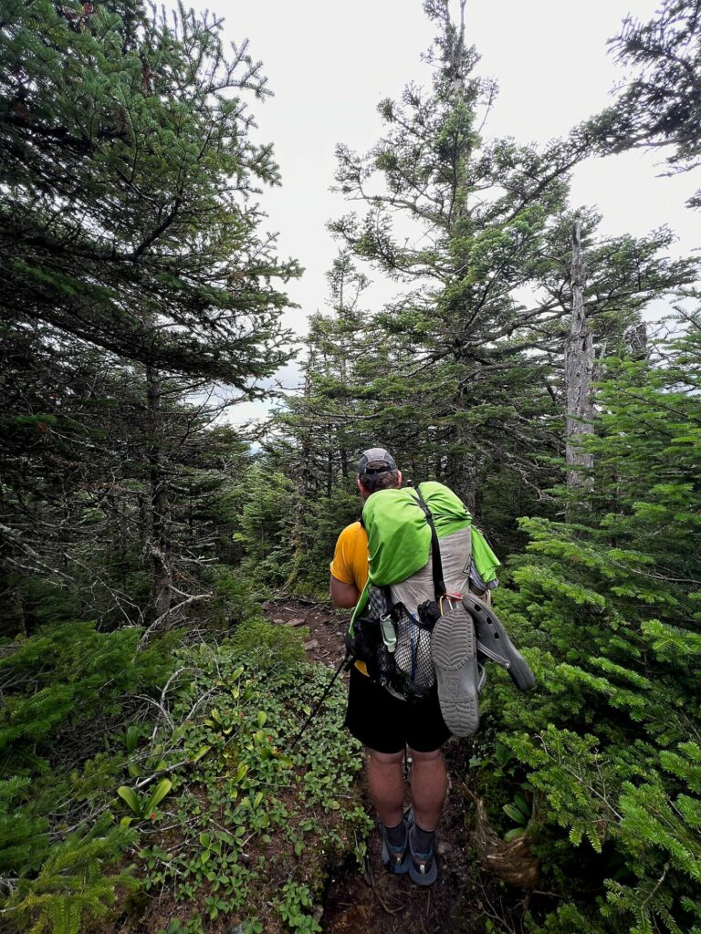 Barrett hiking with his towel drying on his pack, considered a luxury backpacking item